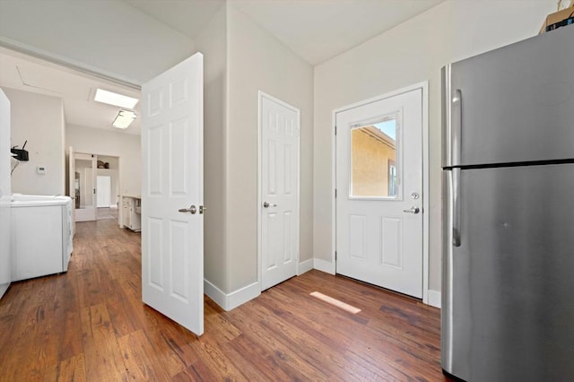 hallway with dark wood-type flooring and washer / clothes dryer