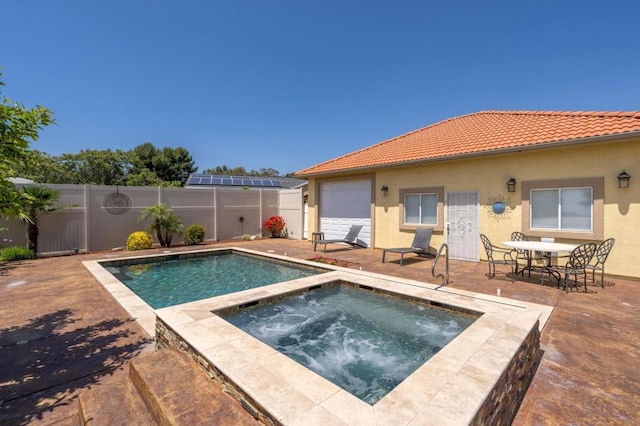 view of swimming pool featuring a patio and an in ground hot tub