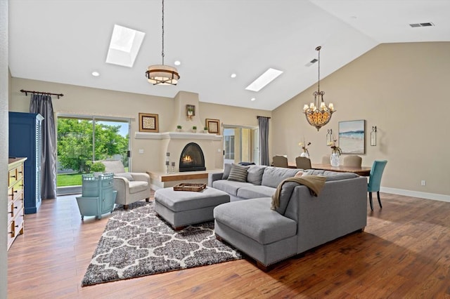 living room featuring hardwood / wood-style flooring and vaulted ceiling with skylight