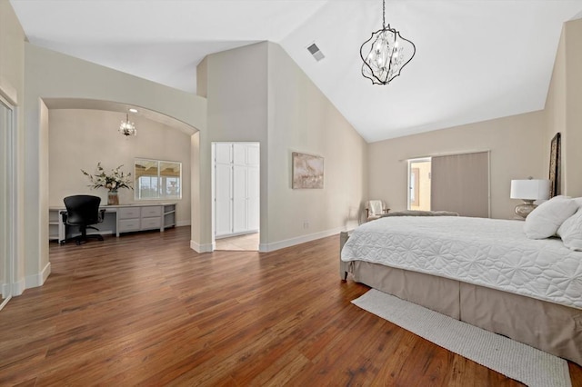 bedroom with high vaulted ceiling, hardwood / wood-style floors, and a notable chandelier