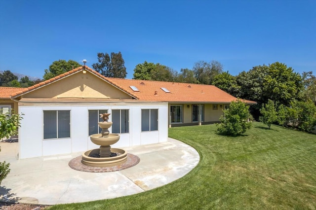 rear view of house featuring a patio and a yard