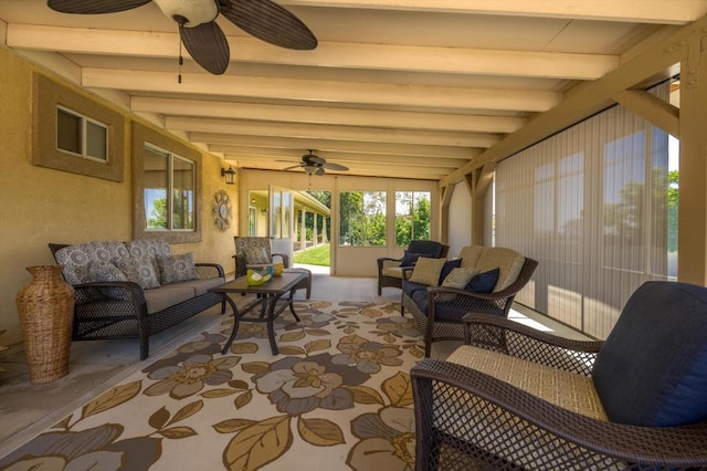 sunroom with ceiling fan and beamed ceiling