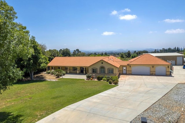 view of front facade with a mountain view, a garage, and a front lawn