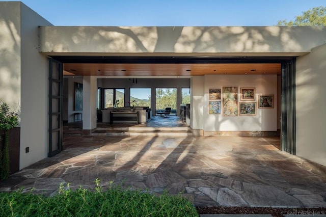 view of exterior entry with a patio area and outdoor lounge area