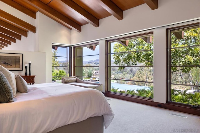 carpeted bedroom with vaulted ceiling with beams