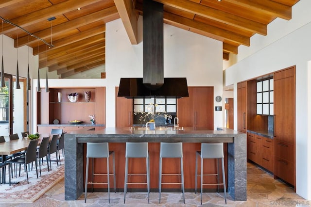 kitchen with beam ceiling, a breakfast bar, and high vaulted ceiling