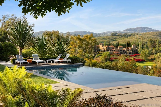 view of swimming pool with a mountain view and a patio