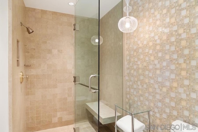 bathroom with a shower with shower door and toilet