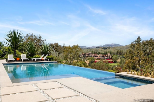 view of pool with a mountain view and a patio