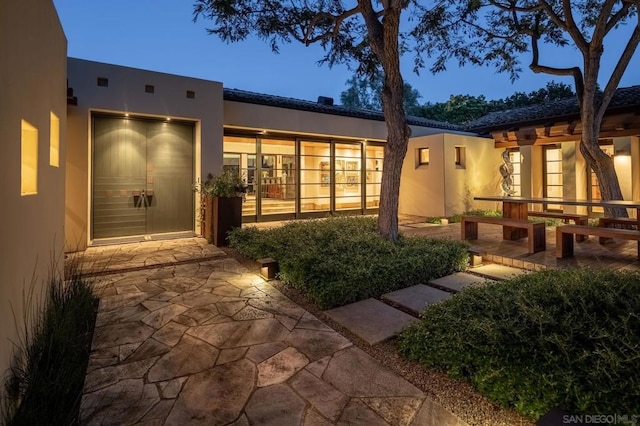 back house at dusk with a patio