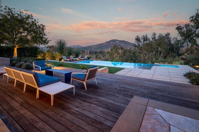 deck at dusk featuring a mountain view