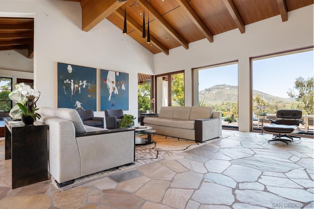 living room featuring a mountain view, high vaulted ceiling, wood ceiling, and beam ceiling