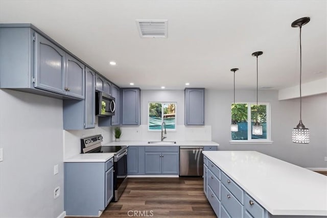 kitchen with sink, stainless steel appliances, dark hardwood / wood-style flooring, and decorative light fixtures