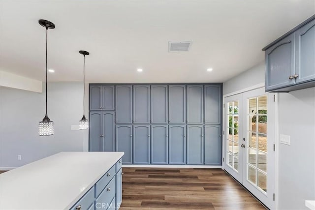 kitchen with dark wood-type flooring, pendant lighting, and french doors