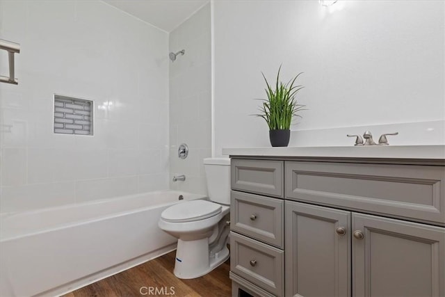 full bathroom with hardwood / wood-style floors, vanity, toilet, and tiled shower / bath