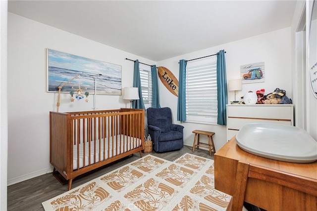 bedroom featuring hardwood / wood-style flooring and a nursery area