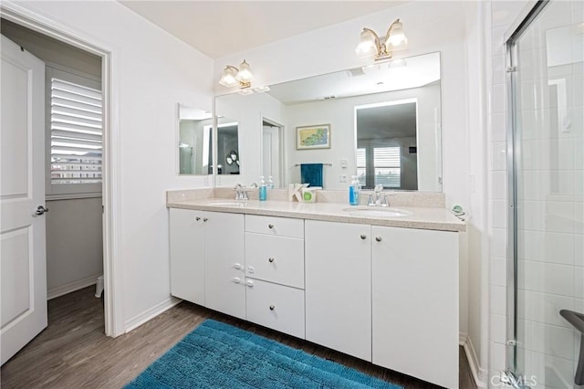 bathroom featuring vanity, wood-type flooring, and a shower with door