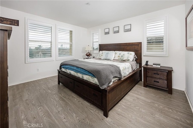 bedroom with multiple windows and light hardwood / wood-style flooring