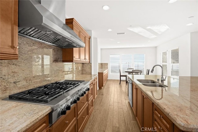 2598 E Temblor Ranch Dr, Brea, CA 92821 - kitchen featuring wall chimney exhaust hood, a sink, stainless steel gas stovetop, light wood-type flooring, and brown cabinetry