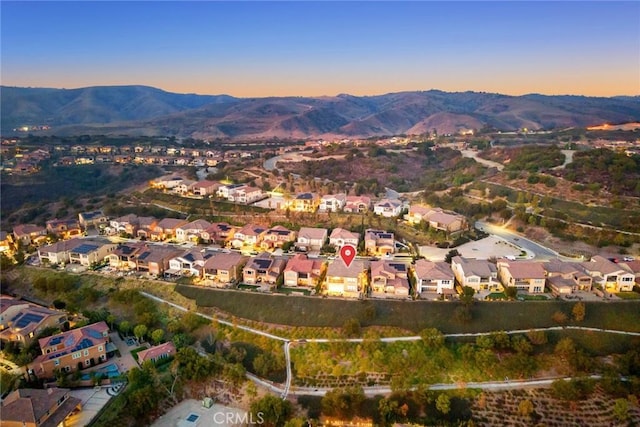 aerial view at dusk featuring a mountain view