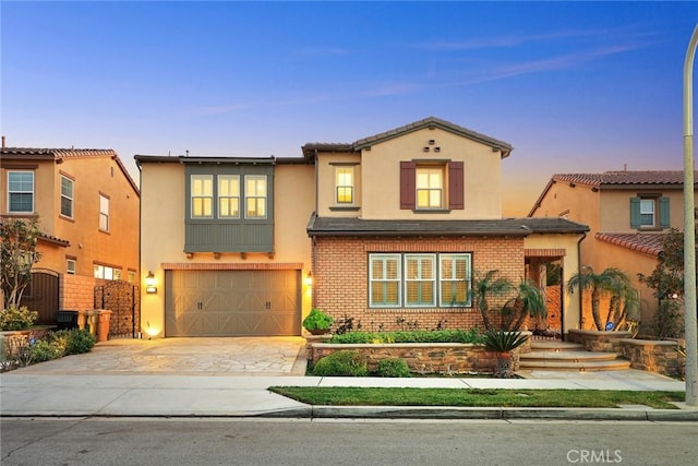 2598 E Temblor Ranch Dr, Brea, CA 92821 - view of front of house featuring an attached garage, driveway, stucco siding, and brick siding