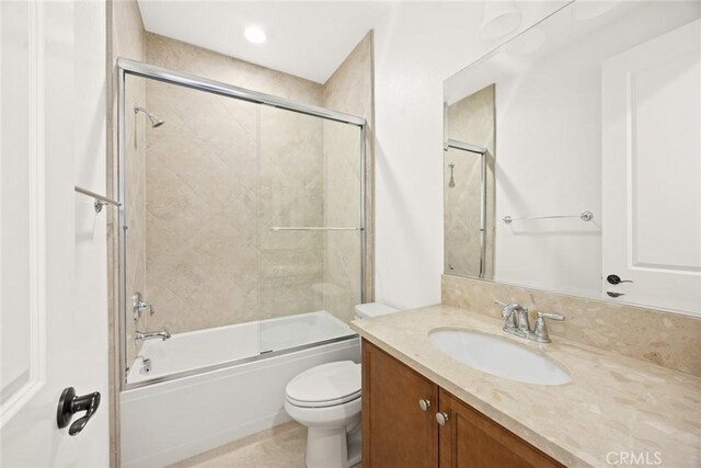 full bathroom with vanity, enclosed tub / shower combo, and toilet