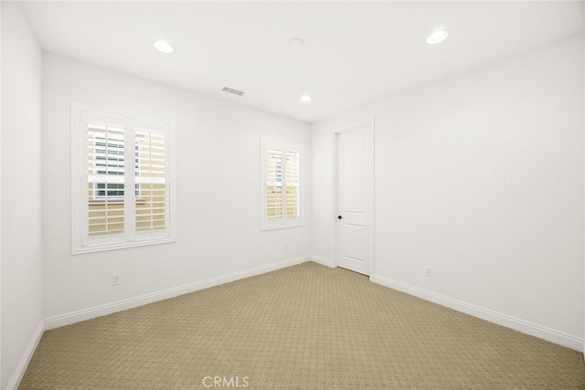 spare room with light carpet and plenty of natural light