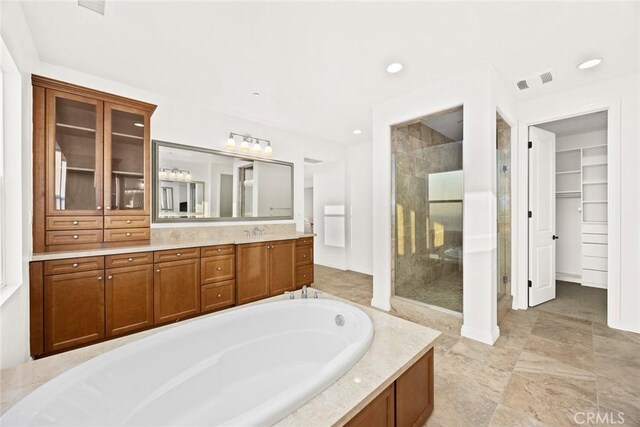 bathroom with vanity and independent shower and bath