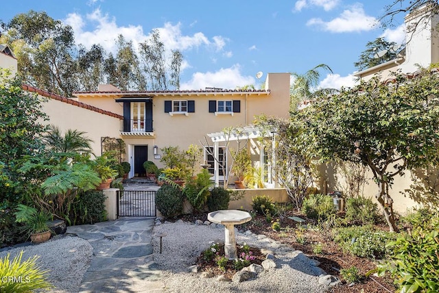 mediterranean / spanish-style home with a pergola and a balcony