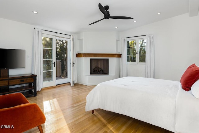 bedroom with hardwood / wood-style flooring, access to outside, and ceiling fan