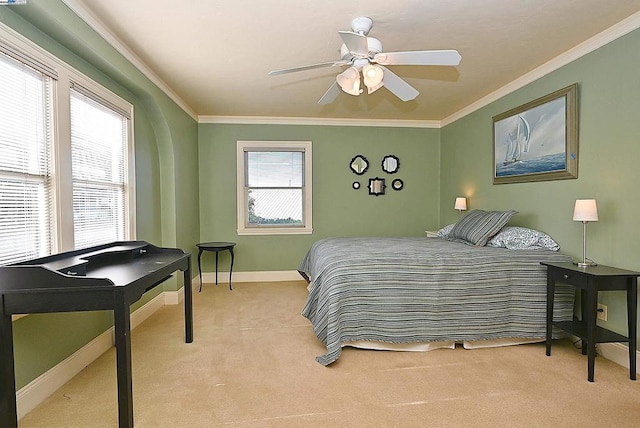 bedroom featuring ceiling fan, ornamental molding, light carpet, and multiple windows