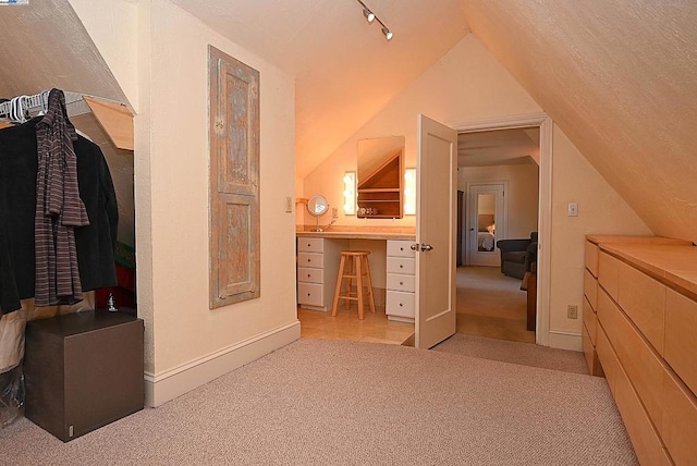 bathroom with lofted ceiling and track lighting