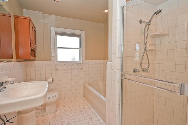 bathroom featuring independent shower and bath, tile walls, tile patterned floors, and toilet