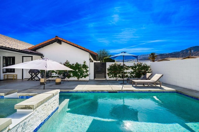 view of pool with a mountain view and a patio area