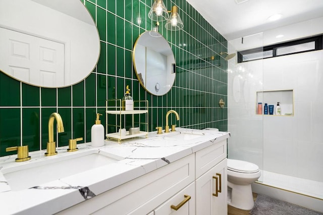 bathroom with tile walls, vanity, toilet, and walk in shower