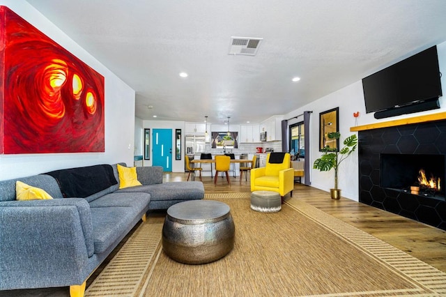 living room featuring wood-type flooring and a fireplace