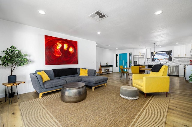 living room with hardwood / wood-style flooring and sink