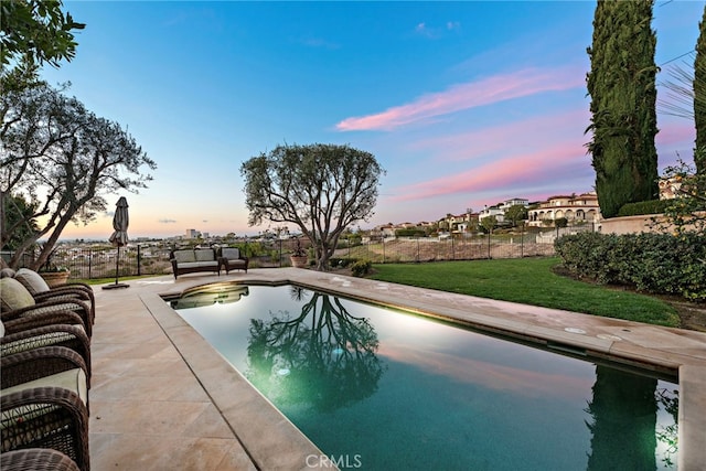 view of pool featuring fence, a patio area, a fenced in pool, and a yard