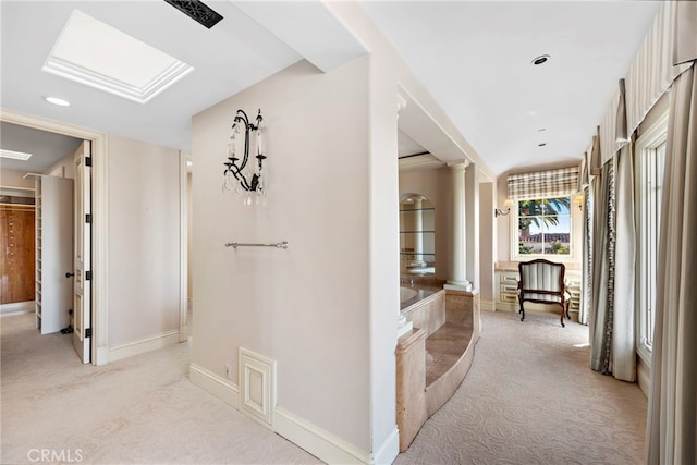 corridor featuring light carpet, decorative columns, baseboards, and recessed lighting