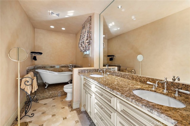 bathroom featuring vanity, a bath, and toilet