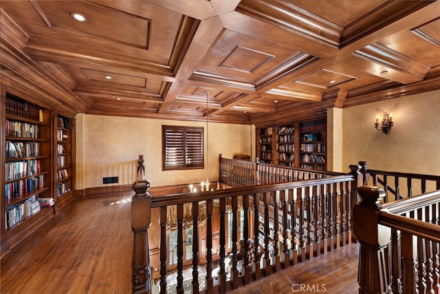 corridor featuring crown molding, coffered ceiling, wooden ceiling, and built in shelves