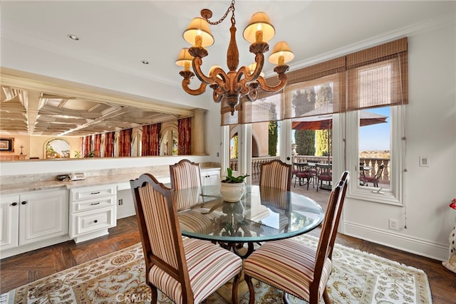 dining room featuring ornamental molding, dark parquet flooring, built in desk, and a notable chandelier