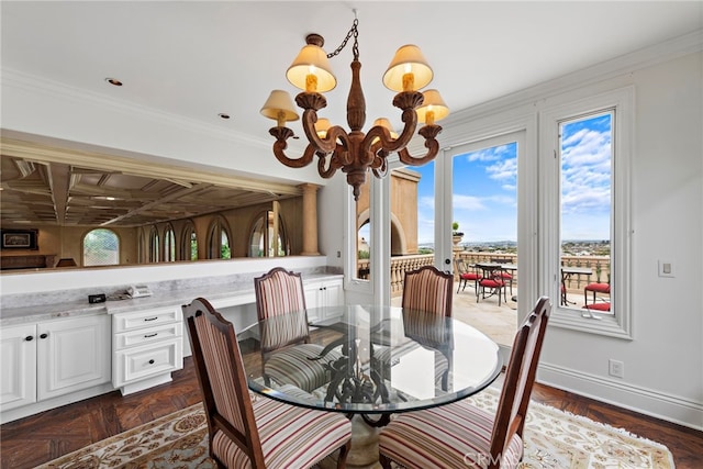 dining room with baseboards, ornamental molding, and a chandelier