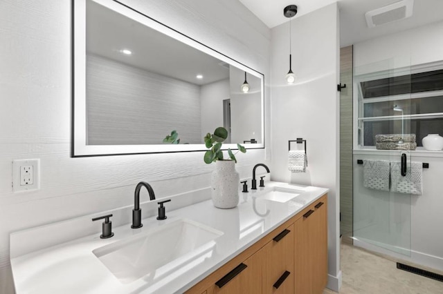 bathroom with vanity and a shower with door