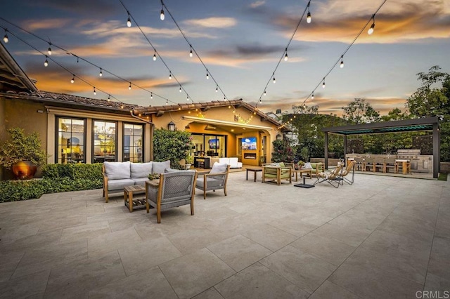 patio terrace at dusk featuring area for grilling and an outdoor living space