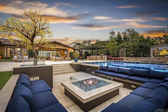 patio terrace at dusk with an outdoor living space with a fire pit