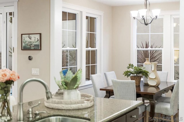 dining room with sink and an inviting chandelier