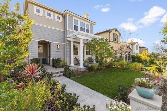 view of front property featuring a pergola and a front lawn