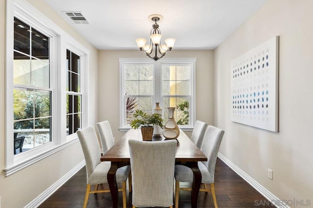 dining space with an inviting chandelier and dark wood-type flooring