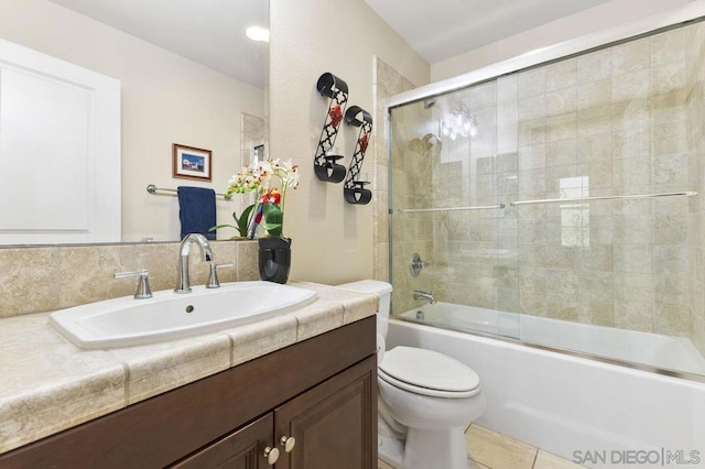 full bathroom featuring vanity, combined bath / shower with glass door, tile patterned floors, and toilet